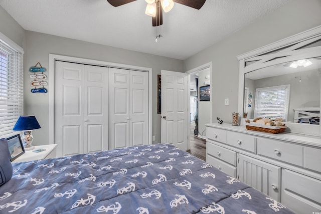 bedroom with a textured ceiling, ceiling fan, a closet, and wood finished floors