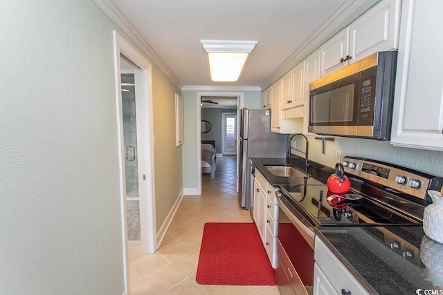 kitchen with white cabinets, crown molding, a sink, stainless steel appliances, and light tile patterned floors