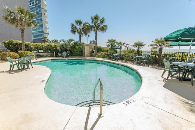 community pool featuring fence and a patio area
