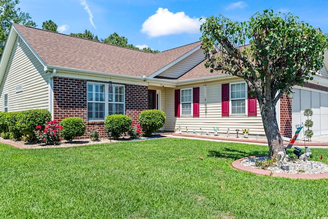 ranch-style house featuring a shingled roof, brick siding, and a front yard