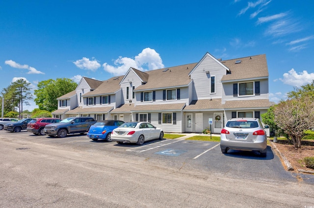 view of front of house with uncovered parking and a shingled roof