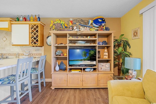living room featuring light wood-type flooring and a textured ceiling