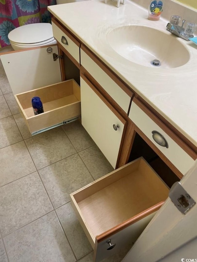 bathroom featuring vanity, tile patterned flooring, and toilet