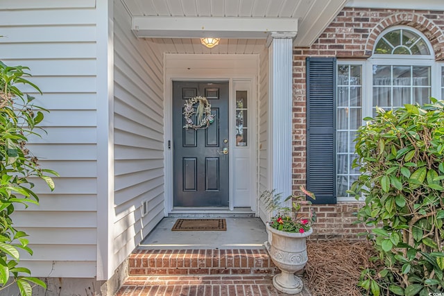 view of exterior entry with brick siding