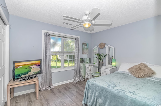 bedroom featuring a textured ceiling, wood finished floors, and visible vents