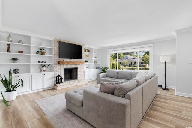 living area with crown molding, built in features, a brick fireplace, light wood-type flooring, and baseboards