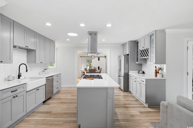 kitchen featuring crown molding, appliances with stainless steel finishes, gray cabinets, and a center island