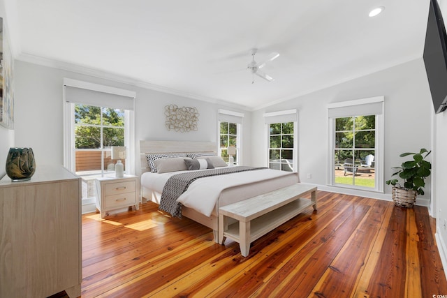bedroom with crown molding, lofted ceiling, multiple windows, and light wood-type flooring