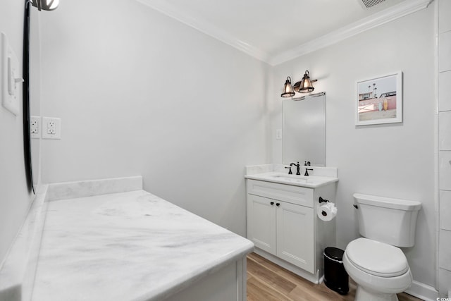 bathroom featuring crown molding, toilet, wood finished floors, and vanity