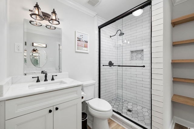 bathroom featuring crown molding, toilet, visible vents, and a shower stall