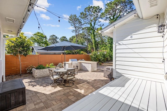 exterior space with visible vents, outdoor dining space, area for grilling, a fenced backyard, and a patio