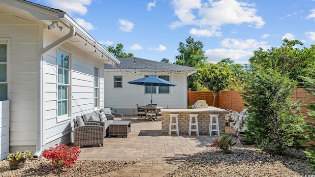 view of patio with fence, outdoor lounge area, and outdoor dry bar