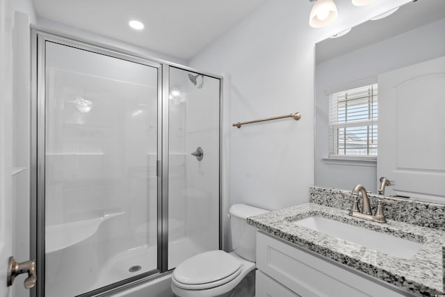 bathroom with vanity, toilet, and a stall shower