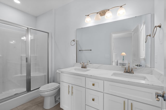 bathroom with a sink, a stall shower, and toilet