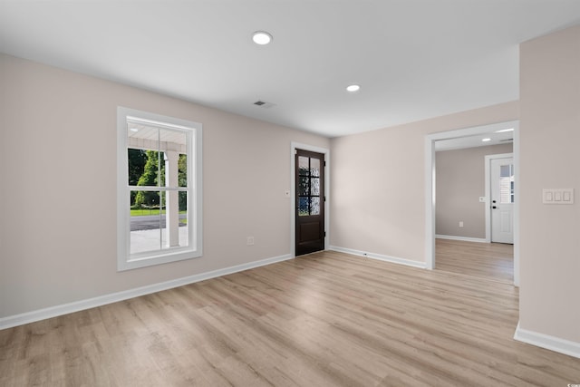 spare room featuring baseboards, a wealth of natural light, light wood finished floors, and recessed lighting