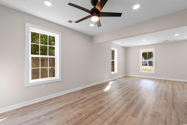 unfurnished room with light wood-style floors, plenty of natural light, and visible vents