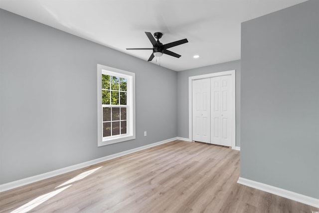 unfurnished bedroom with a closet, wood finished floors, recessed lighting, ceiling fan, and baseboards