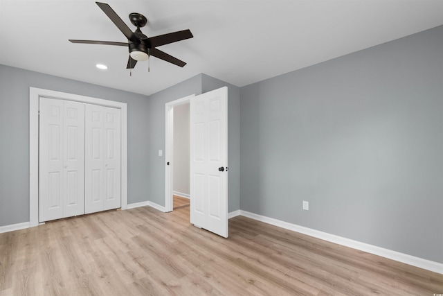 unfurnished bedroom with baseboards, light wood-style floors, a closet, and recessed lighting