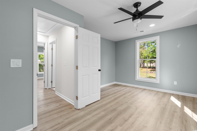 unfurnished bedroom featuring light wood-style flooring, attic access, baseboards, and visible vents