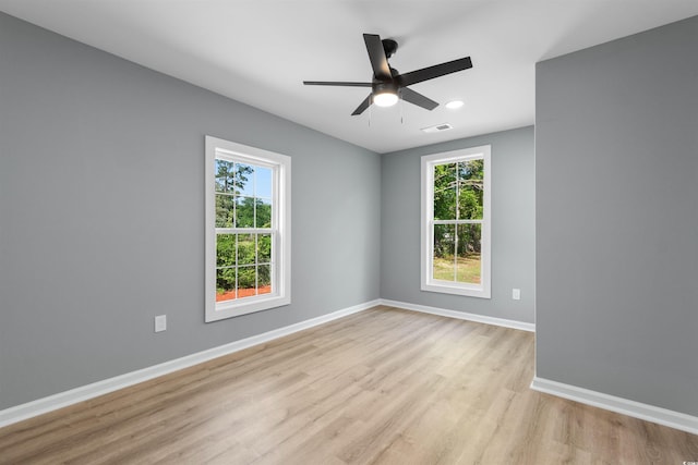 unfurnished room with light wood-style flooring, a wealth of natural light, and visible vents