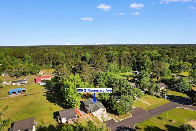 birds eye view of property featuring a view of trees