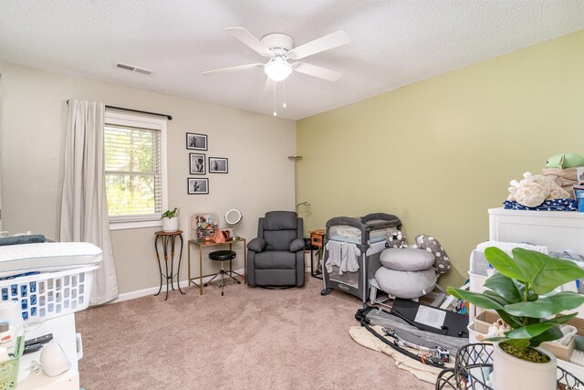 bedroom with a ceiling fan, carpet flooring, a textured ceiling, and visible vents