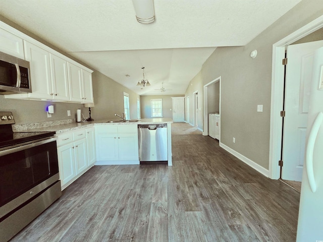 kitchen featuring a peninsula, light wood-style flooring, a sink, white cabinetry, and appliances with stainless steel finishes