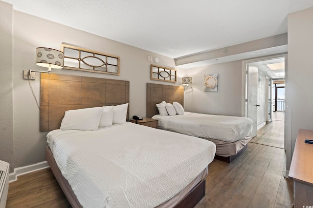 bedroom featuring baseboards and wood finished floors