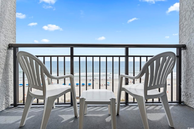 balcony featuring a water view and a view of the beach
