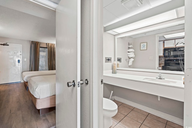 bathroom with a sink, tile patterned floors, and toilet