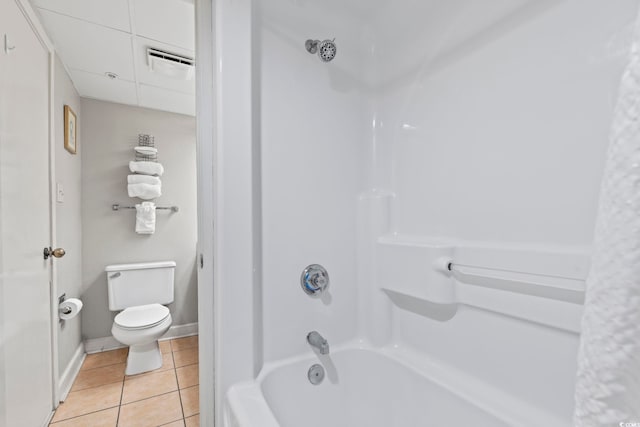 bathroom featuring shower / bathtub combination with curtain, tile patterned floors, and toilet
