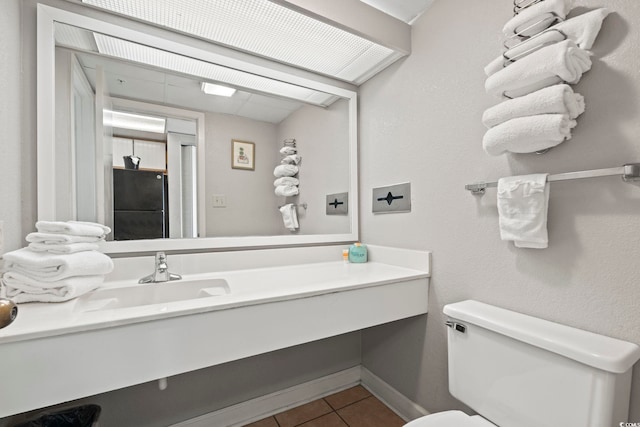 bathroom featuring vanity, tile patterned flooring, and toilet