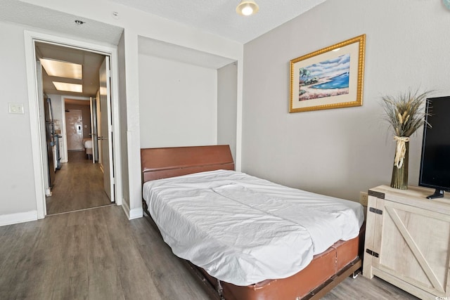 bedroom with baseboards and wood finished floors