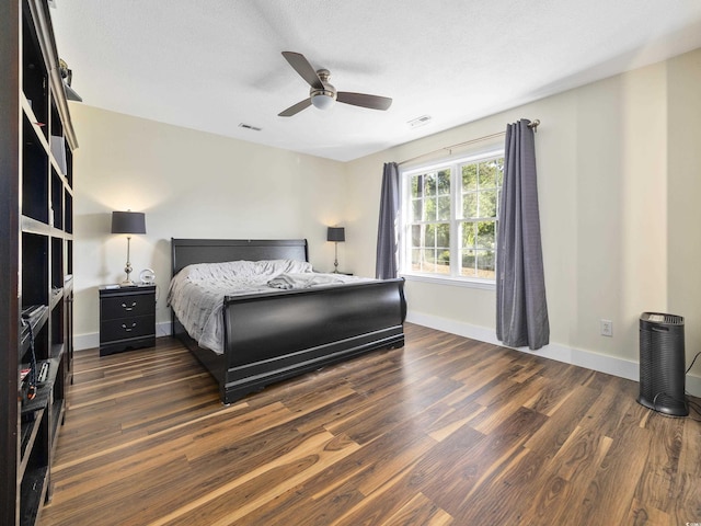 bedroom featuring baseboards, visible vents, a ceiling fan, and dark wood-type flooring