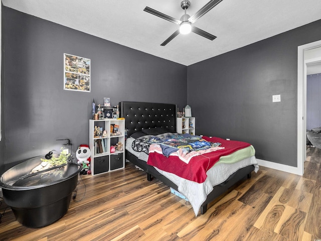 bedroom featuring baseboards, a ceiling fan, and wood finished floors