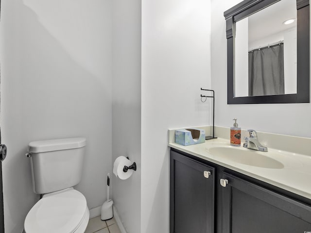bathroom with vanity, tile patterned flooring, baseboards, and toilet