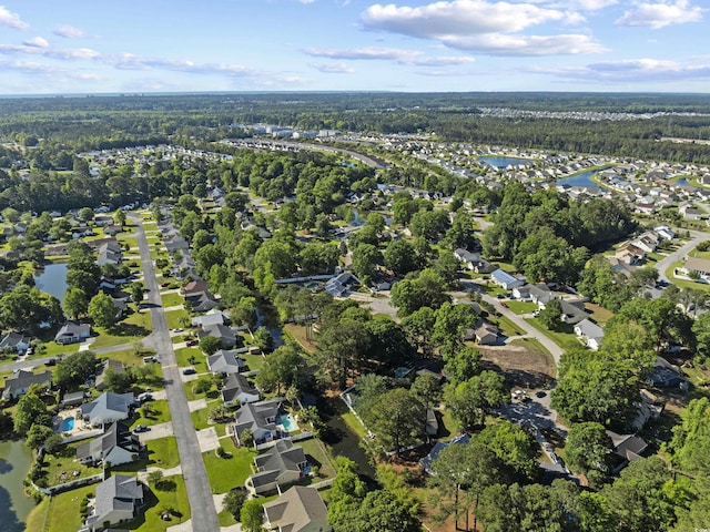 birds eye view of property featuring a water view, a residential view, and a wooded view