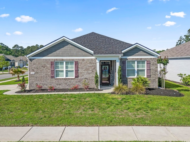 view of front of home featuring brick siding and a front yard