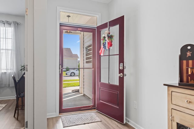 foyer with baseboards and light wood-style flooring