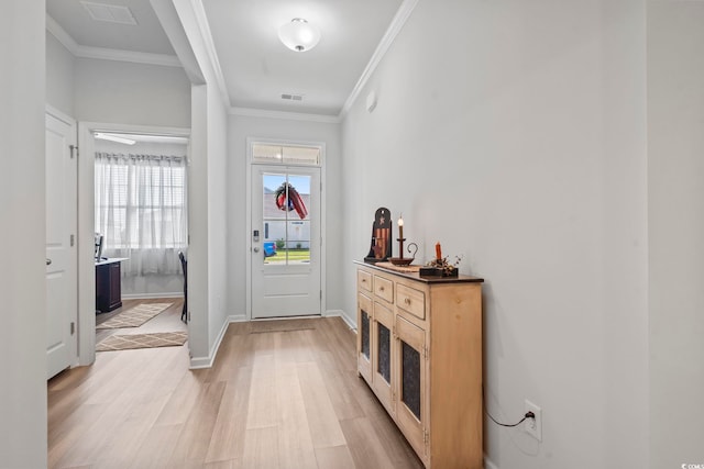 foyer entrance with crown molding, baseboards, visible vents, and light wood-style flooring