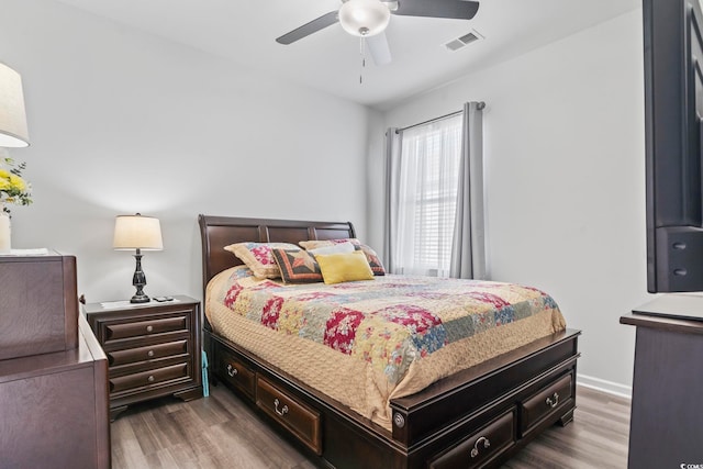 bedroom with visible vents, dark wood-style flooring, and ceiling fan