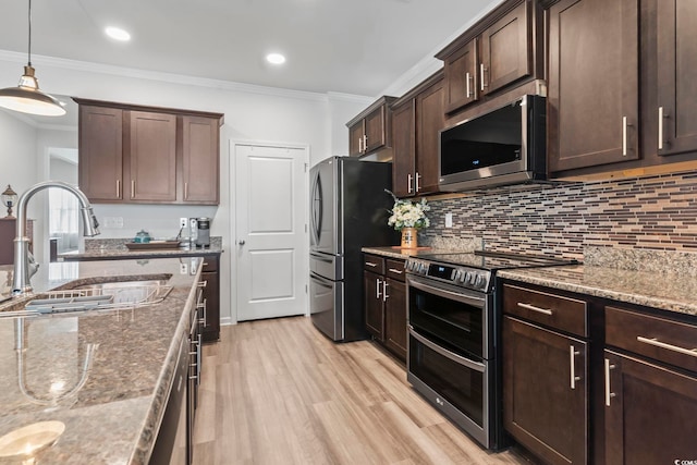 kitchen with decorative backsplash, ornamental molding, a sink, stone counters, and appliances with stainless steel finishes