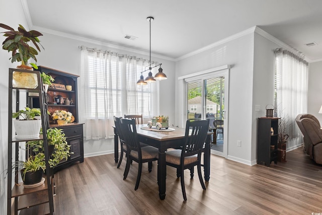 dining area featuring visible vents, baseboards, and wood finished floors