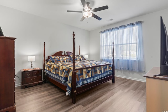 bedroom featuring a ceiling fan, baseboards, visible vents, and light wood-type flooring