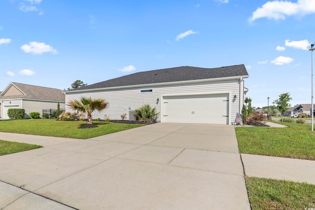 view of side of home featuring a lawn, concrete driveway, and a garage