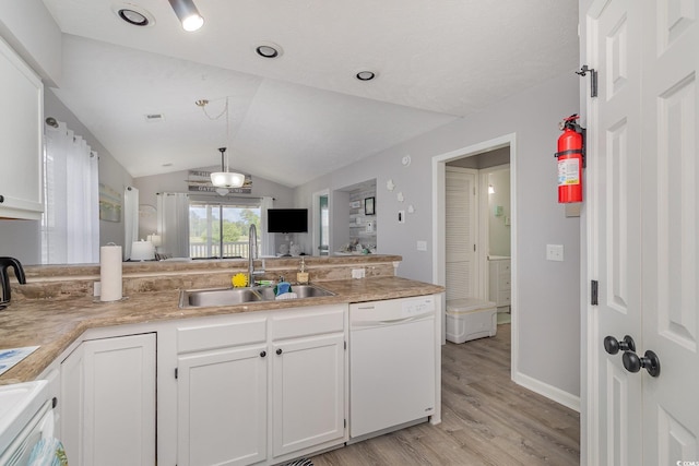 kitchen with white dishwasher, vaulted ceiling, a sink, a peninsula, and light wood-style flooring