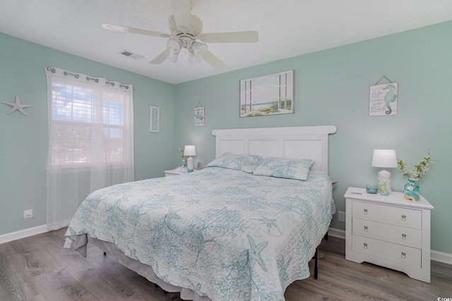 bedroom with baseboards, wood finished floors, and visible vents