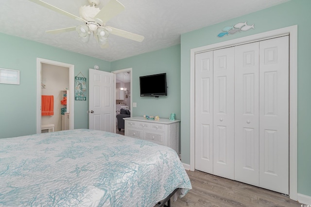 bedroom with baseboards, ceiling fan, a closet, and wood finished floors