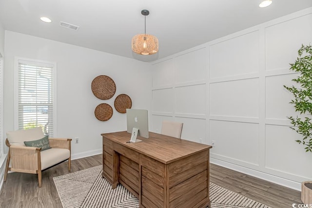 office featuring a decorative wall, recessed lighting, baseboards, wood finished floors, and visible vents