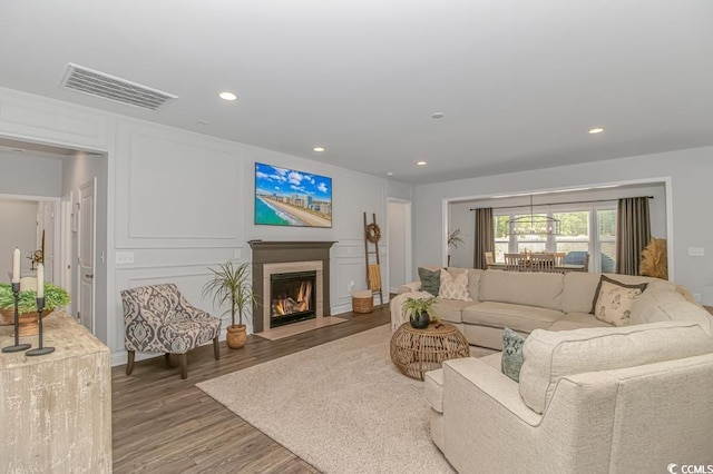 living room with visible vents, a fireplace with flush hearth, wood finished floors, and recessed lighting